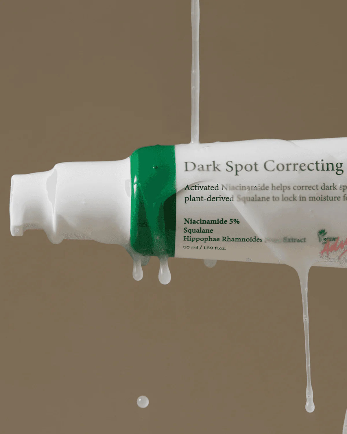 Tube of dark spot correcting cream with visible text on a beige background