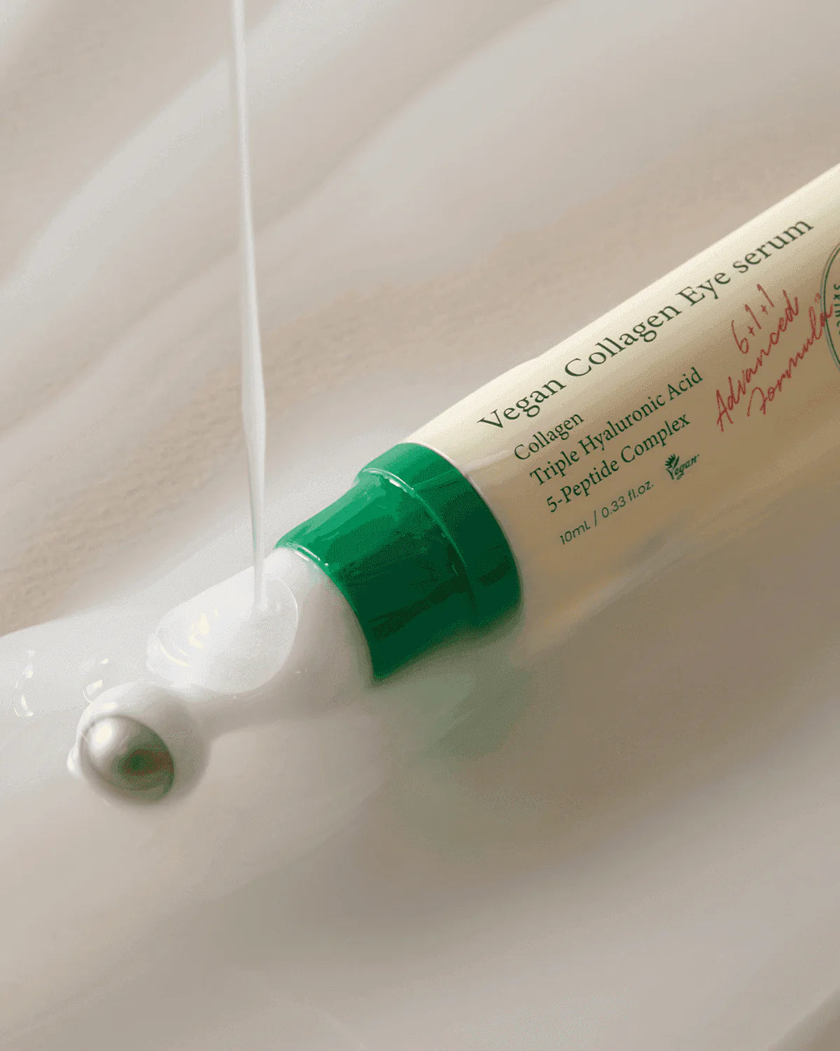Vegan Collagen Eye serum with green cap and white body on a light background